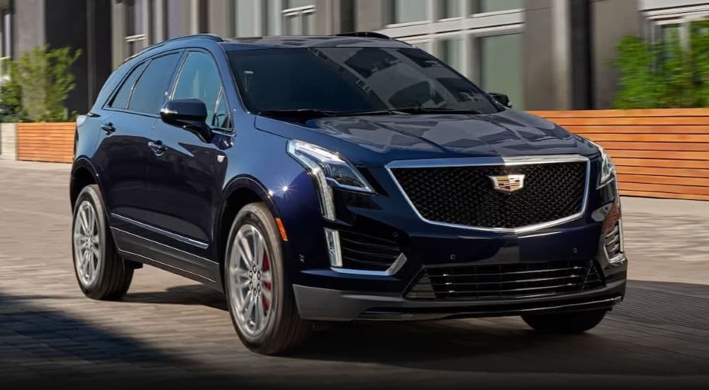A blue 2023 Cadillac XT5 is shown parked by a Cadillac dealer near Troy.