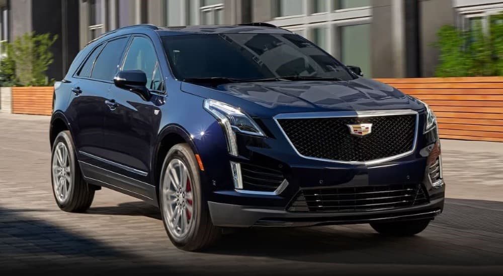 A blue 2023 Cadillac XT5 is shown parked by a Cadillac dealer near Troy.