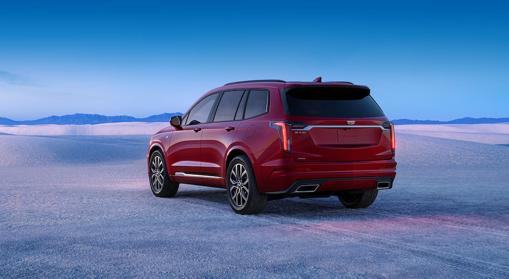 Rear view of a red 2024 Cadillac XT6 parked in a snowy field.