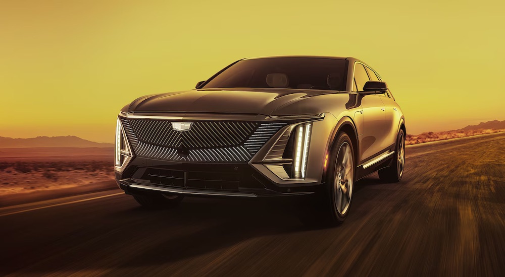 A black 2024 Cadillac LYRIQ driving from a Cadillac dealer near Dearborn.