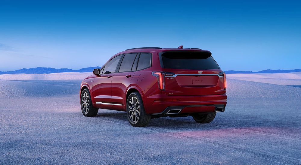 A red 2024 Cadillac XT6 for sale is shown from the rear at an angle.