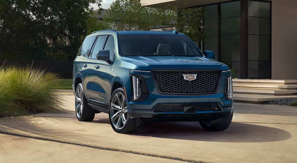 A blue 2025 Cadillac Escalade parked on a driveway.