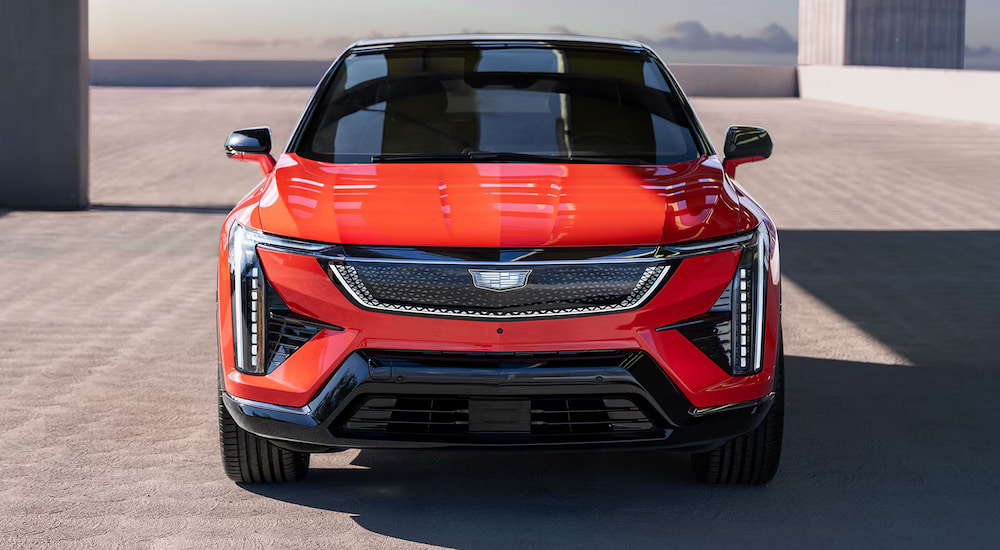 Front angle view of a red 2025 Cadillac OPTIQ parked after visiting a Cadillac dealer near Farmington.