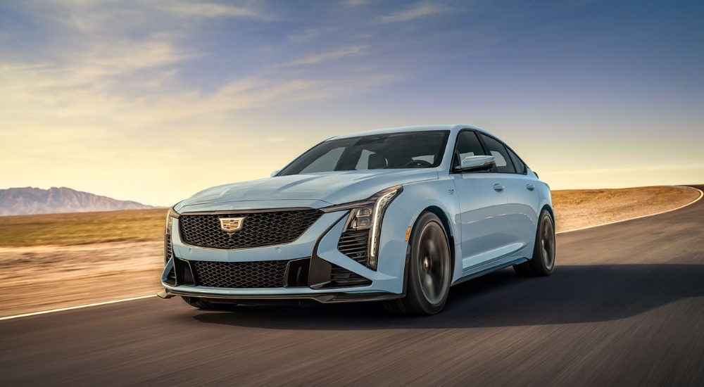 A sky blue 2025 Cadillac CT5-V driving on an open highway.