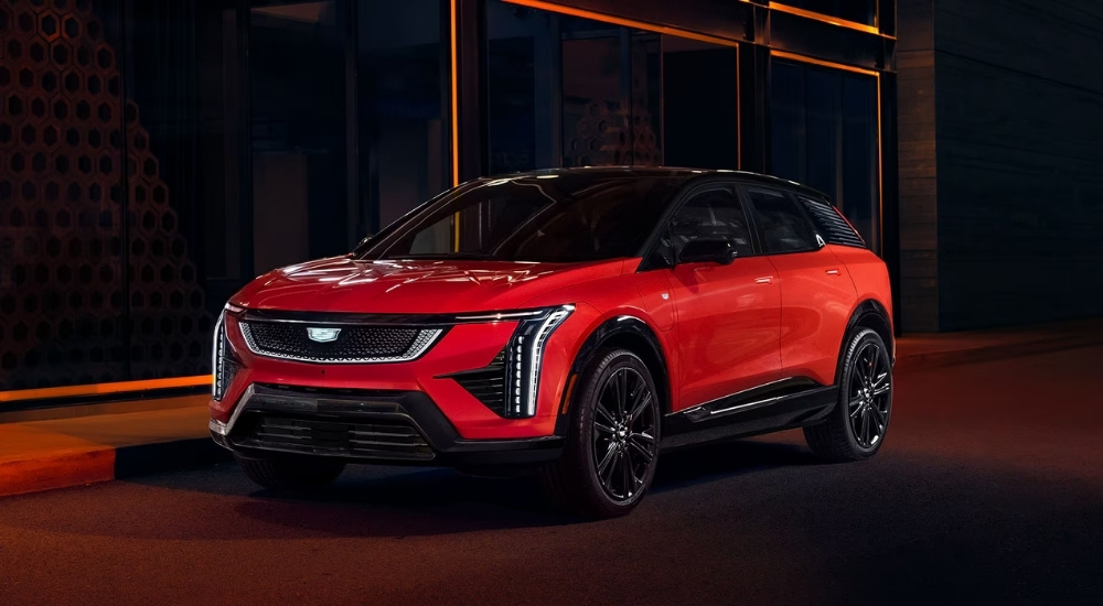 A red 2025 Cadillac OPTIQ in dramatic night lighting.