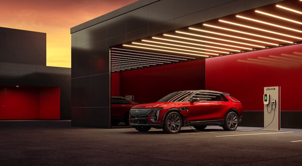 A red 2025 Cadillac LYRIQ is shown from the side while charging.