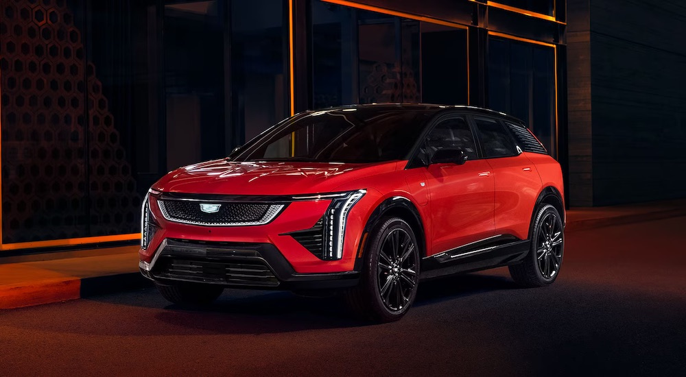 A red 2025 Cadillac OPTIQ is shown from the front at an angle after leaving a Cadillac dealer near Commerce Township.