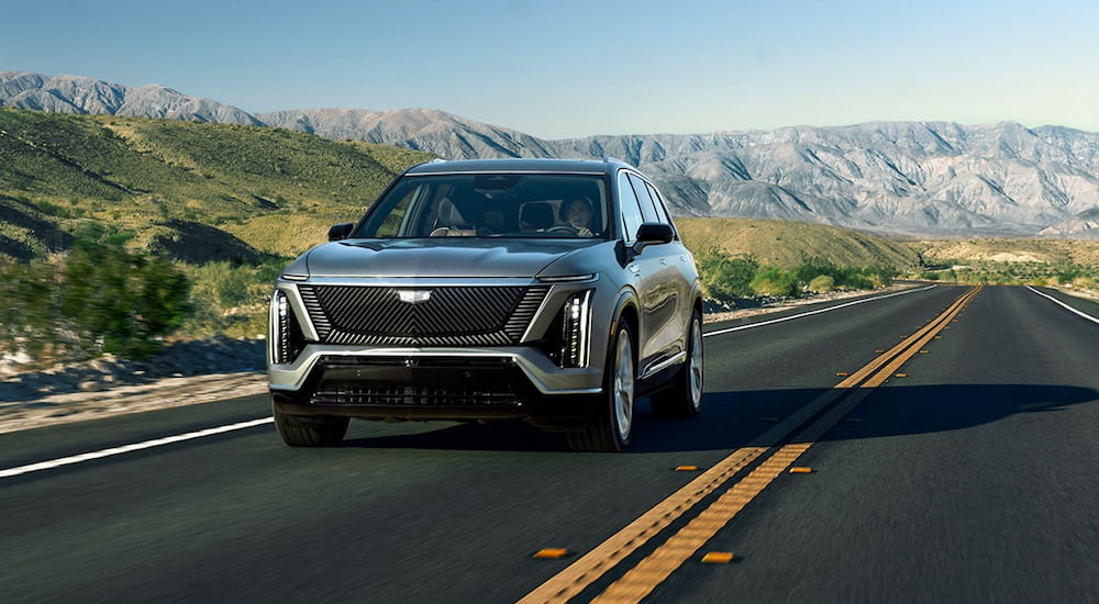 Grey 2026 Cadillac VISTIQ driving down an open road.