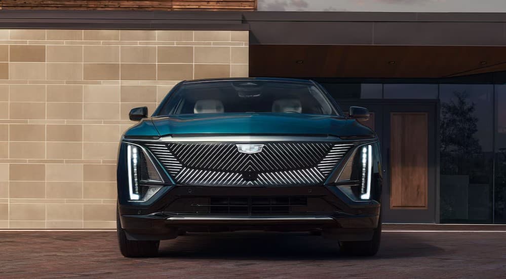 A green 2025 Cadillac LYRIQ parked near a Cadillac dealer.