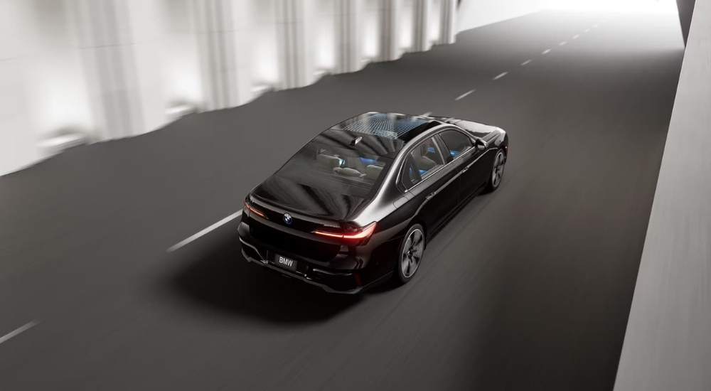 A black 2024 BMW i7 driving on a highway.
