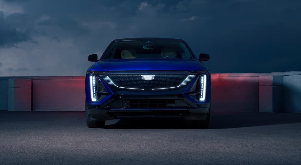 A blue 2027 Cadillac LYRIQ parked at night.