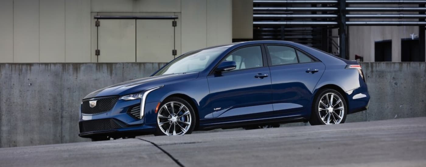 Blue 2020 Cadillac CT4 driving around a bend.