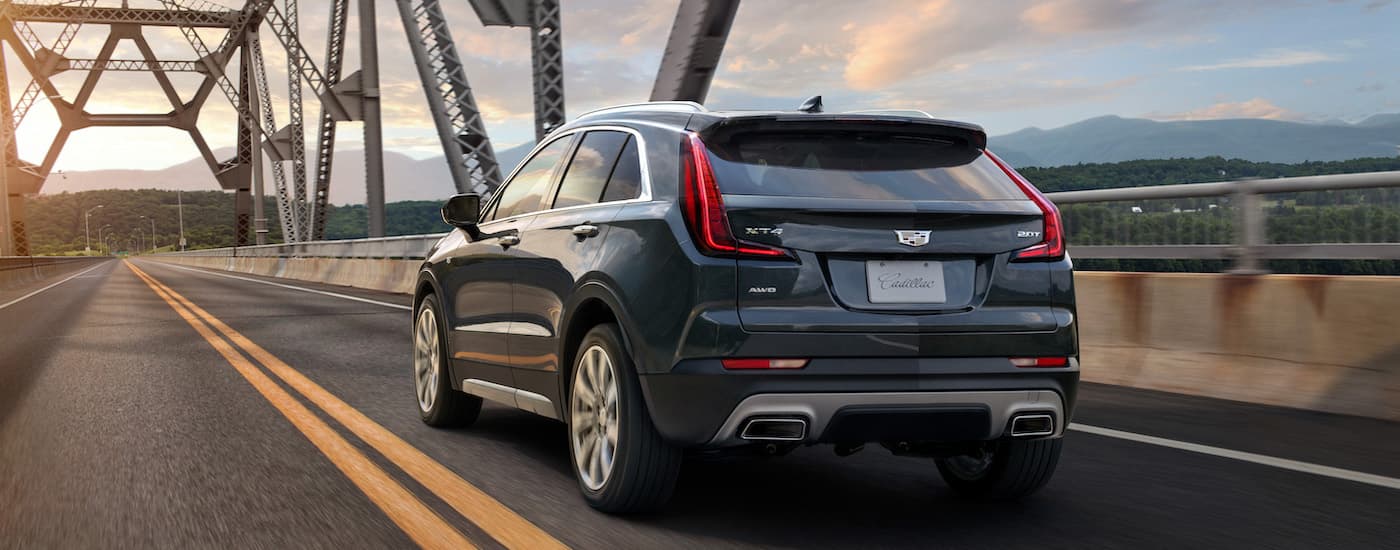 Rear of a grey 2020 Cadillac XT4 driving across a bridge.