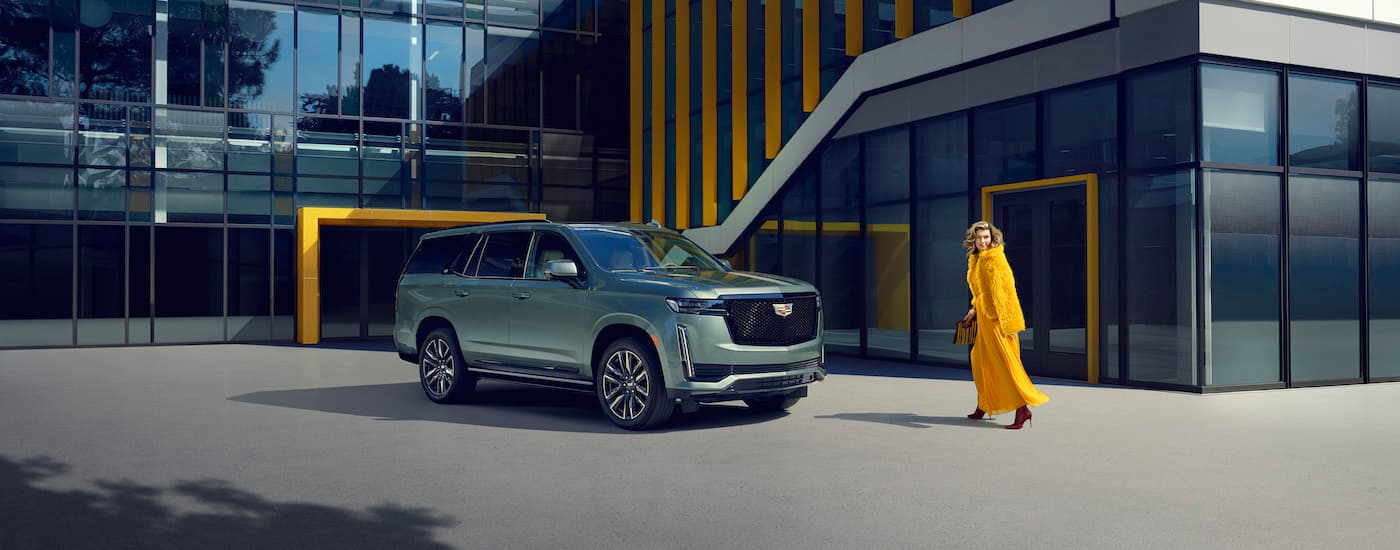 A green 2024 Cadillac Escalade is shown from the side near a Cadillac dealer near Novi.