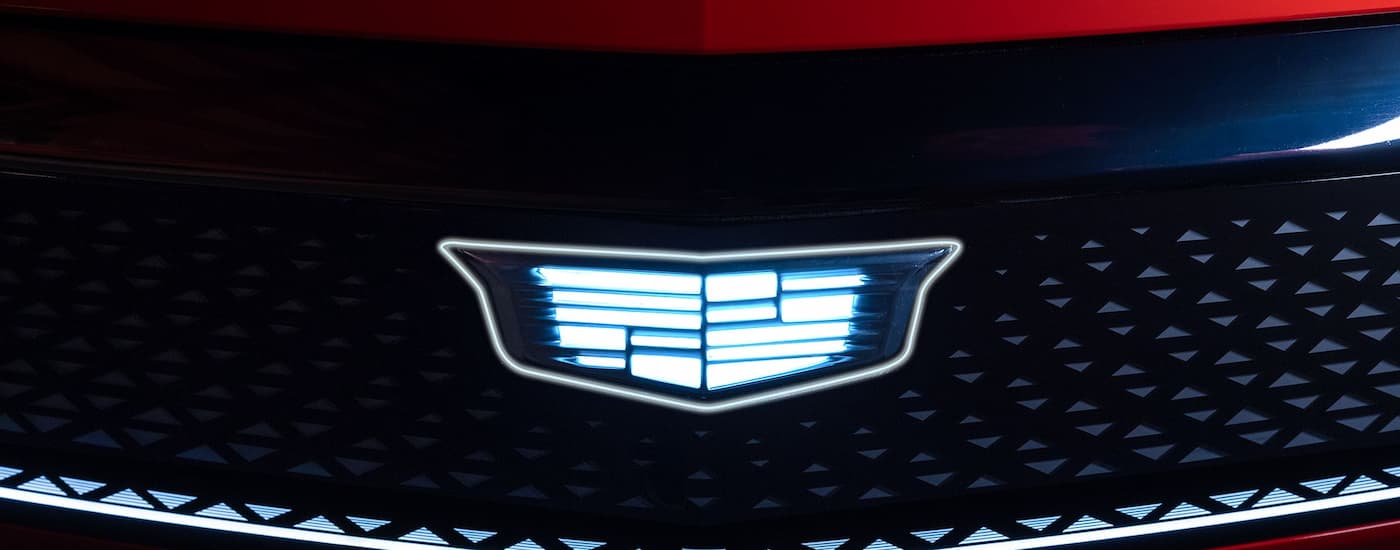 Close-up on the badge of a red 2026 Cadillac OPTIQ-V.