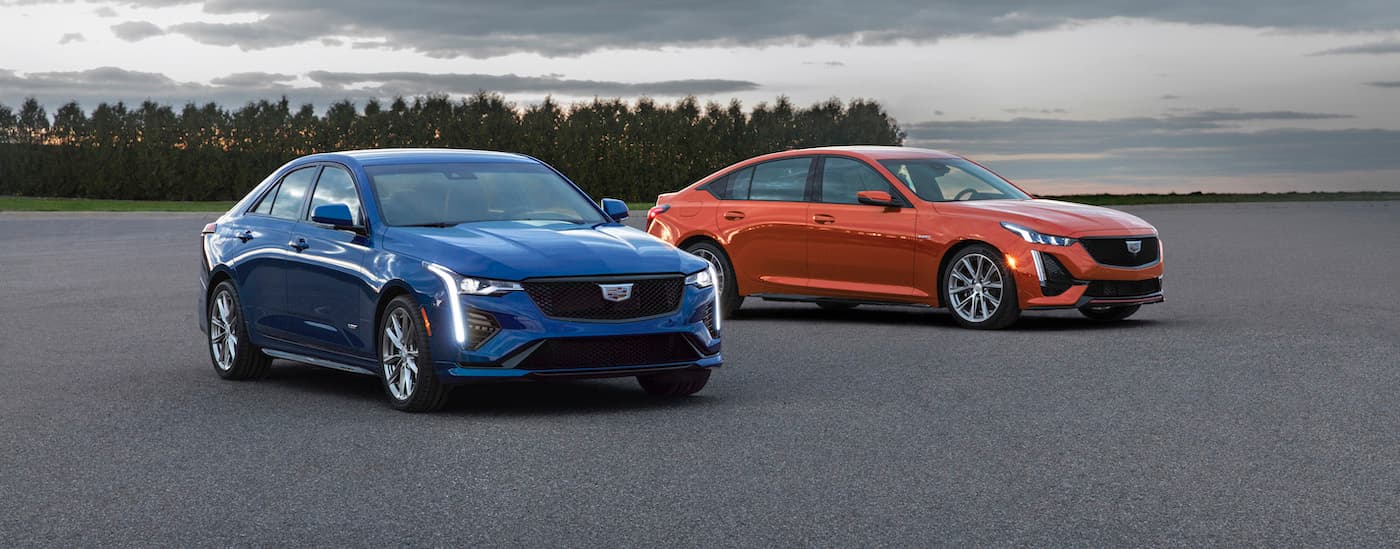A blue 2020 Cadillac CT4-V and an orange CT5-V parked.