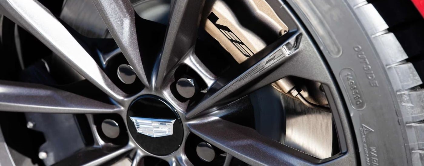 A close up shows a rim on a red 2022 Cadillac CT4-V Blackwing.