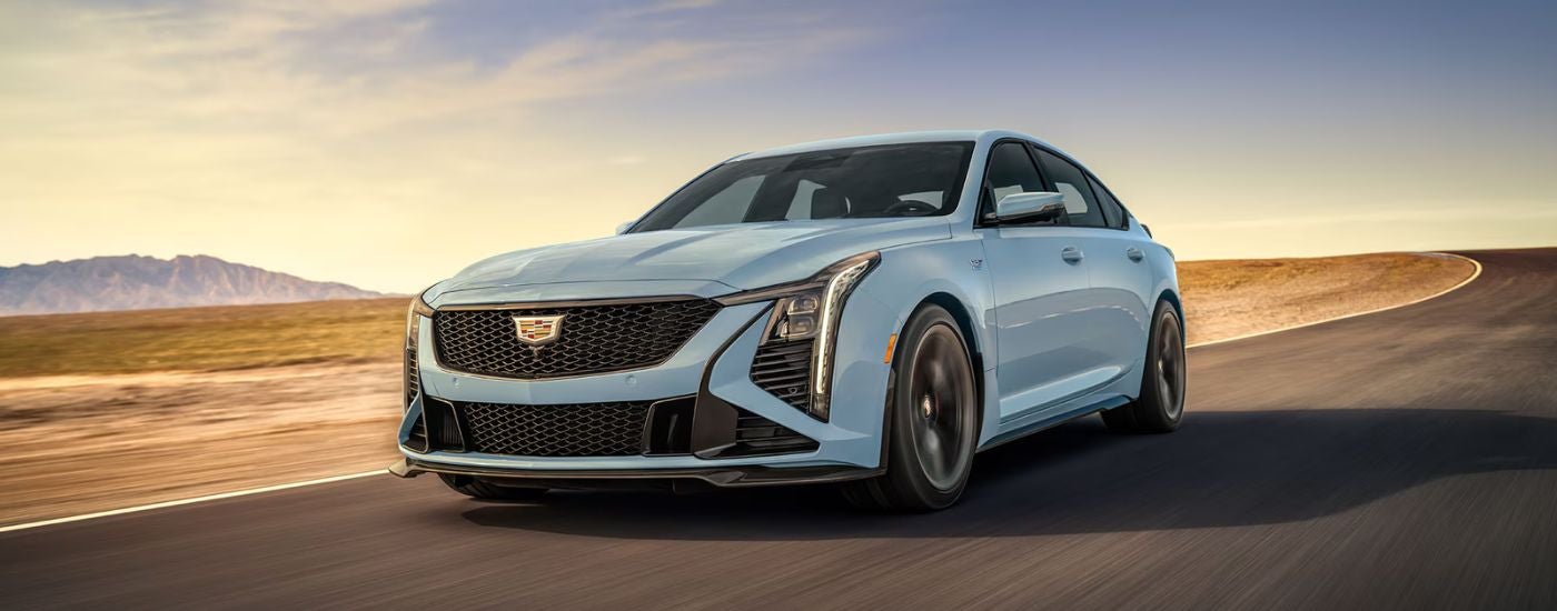A pale blue 2025 Cadillac CT5-V driving on an open track.
