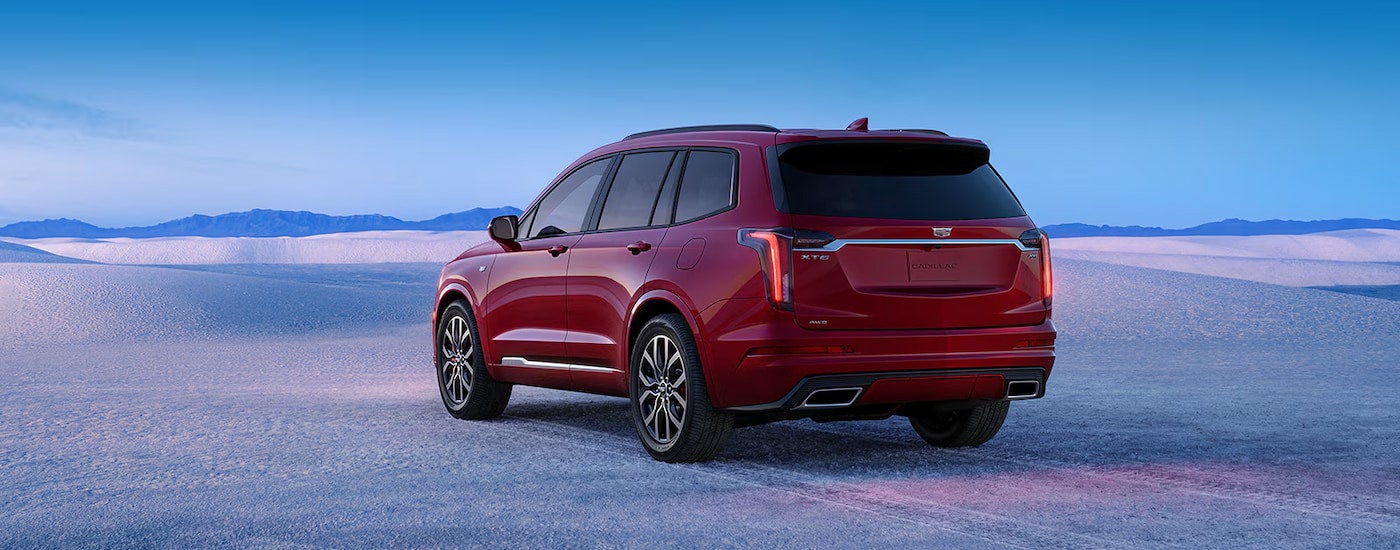 Rear view of a red 2024 Cadillac XT6 parked in a snowy field.