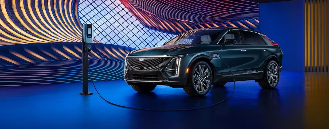A dark blue 2024 Cadillac LYRIQ parked in a showroom.