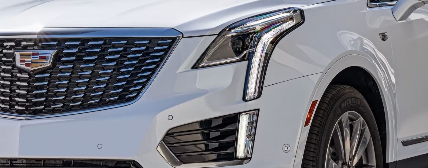 A close up of the front headlight on a white 2023 Cadillac XT5 is shown.