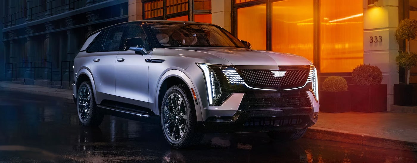 A silver 2025 Cadillac Escalade IQ parked on a city street.