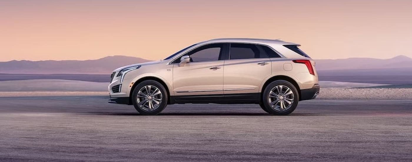 A white 2024 Cadillac XT5 is shown from a side angle while parked.