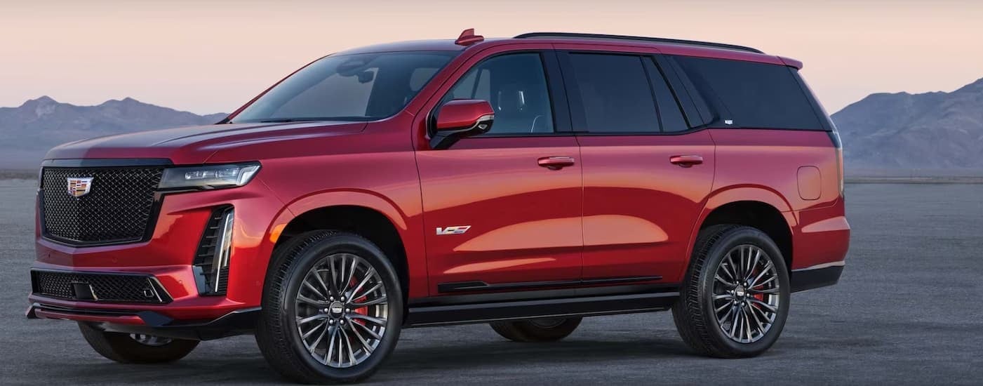 A red 2025 Cadillac Escalade-V parked off-road.