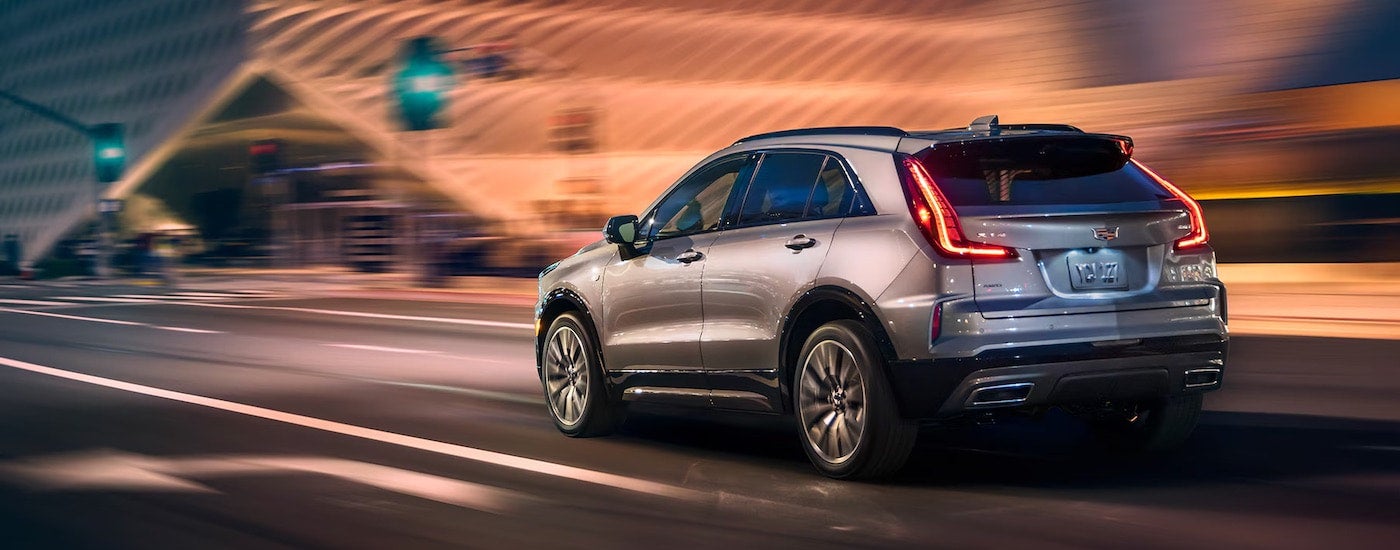 A silver 2024 Cadillac XT4 for sale is shown from the rear at an angle.