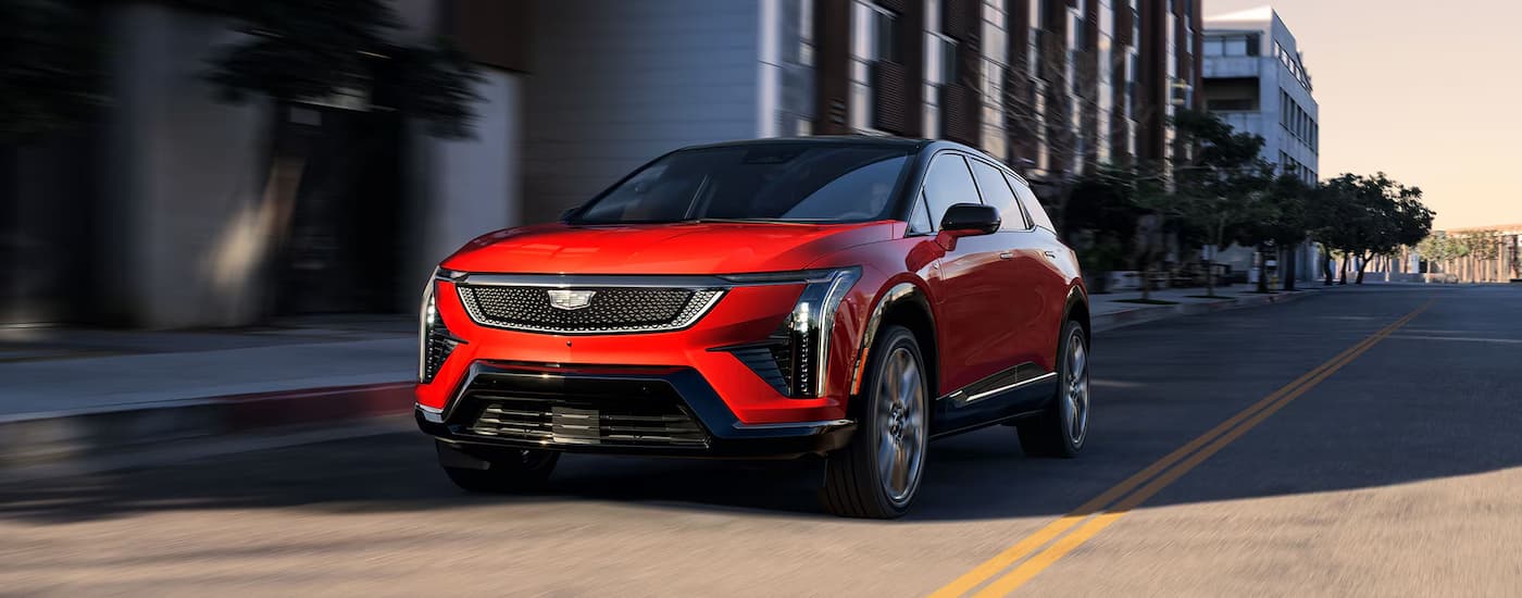 A red 2026 Cadillac OPTIQ driving in a city